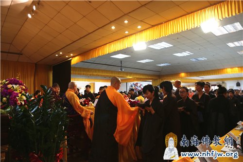 受持五戒弟子恭敬地手托缦衣,礼请印顺大和尚加持